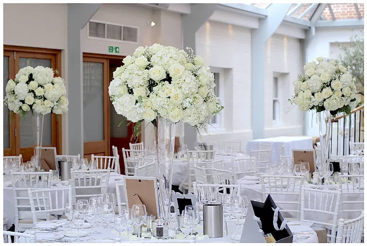tall white wedding centrepiece, vase centrepiece of white hydrangeas roses and gypsophila. botleys mansion white wedding flowers, all white wedding flowers centrepiece, table centrepiece with a dome of white flowers