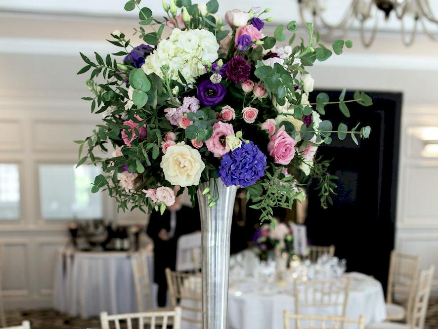 colourful wedding flowers centrepiece at pennyhill park wedding, pink purple wedding flowers at pennyhill park wedding